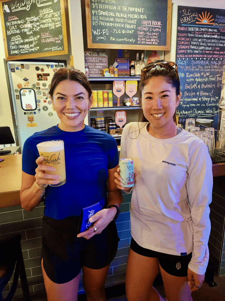 Two women holding drinks in a bar.